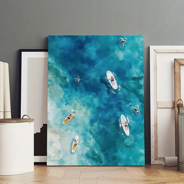 Large aerial ocean canvas print showing surfboards and boats on turquoise water displayed in modern art studio