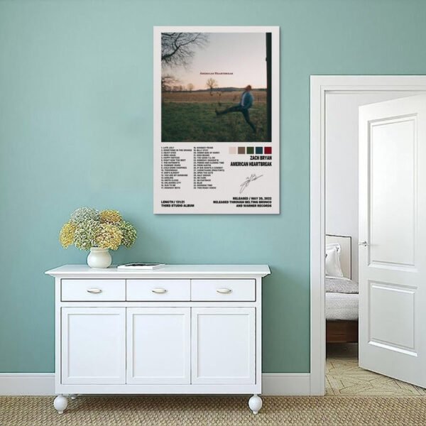 Zach Bryan American Heartbreak album poster displayed on sage green wall above white vintage sideboard in modern coastal interior