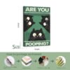 Size demonstration of 24x16 inch "Are You Pooping?" cat canvas print with step-by-step packaging process showing metal hooks installation, wood framing, elaborate workmanship, and final framed canvas.