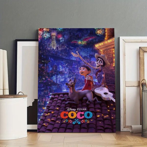 Large Disney Pixar Coco canvas print displayed in art studio showing Miguel, Héctor and Dante with Land of the Dead fireworks scene, surrounded by empty picture frames on wooden floor.