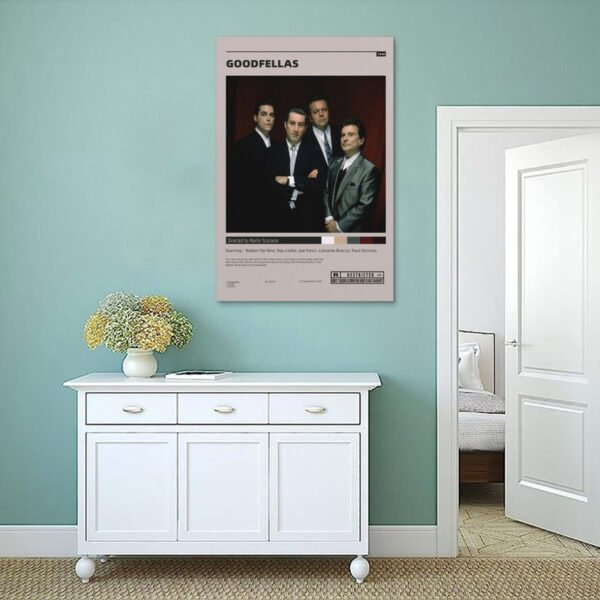 Goodfellas movie poster displayed on mint green wall above white vintage sideboard in minimalist Scandinavian-style interior.