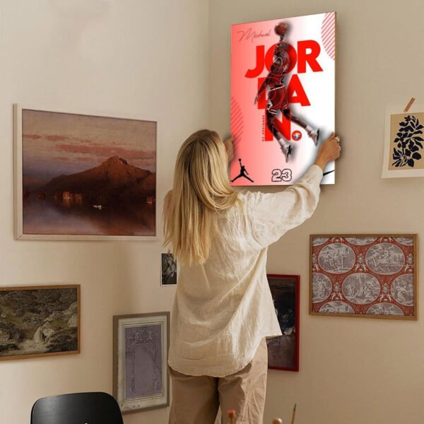 hanging-jordan-canvas-gallery-wall.jpg Person hanging Michael Jordan canvas print on gallery wall showing proper installation and home decor integration