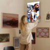Woman hanging Kyrie Irving Mavericks canvas art on home gallery wall with mixed artwork collection