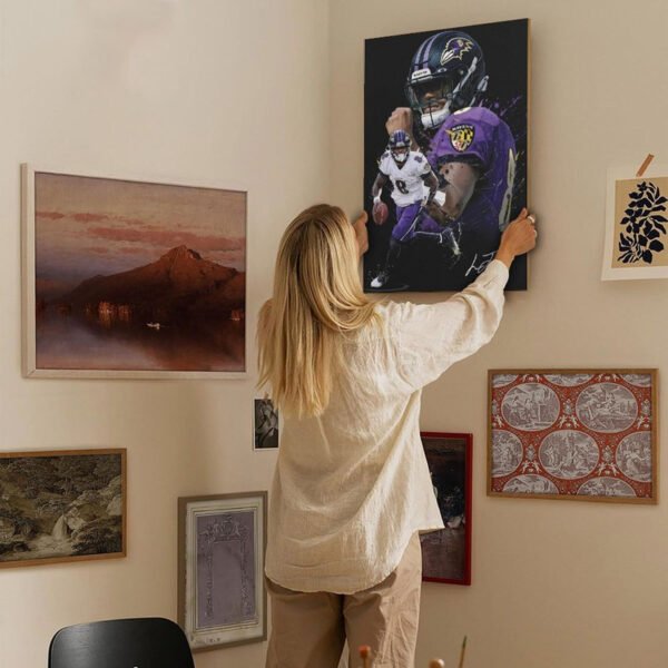 Woman hanging Lamar Jackson Baltimore Ravens canvas print on gallery wall showing home decor integration and artwork sizing