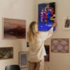 Woman hanging Lamine Yamal Barcelona canvas print on gallery wall in modern home interior with mixed art collection