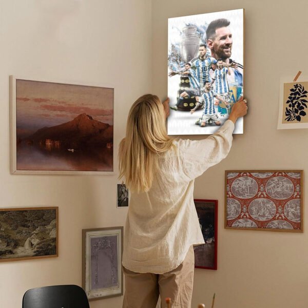 Woman hanging Messi Argentina championship poster on gallery wall as part of modern home decor interior design with various framed artworks