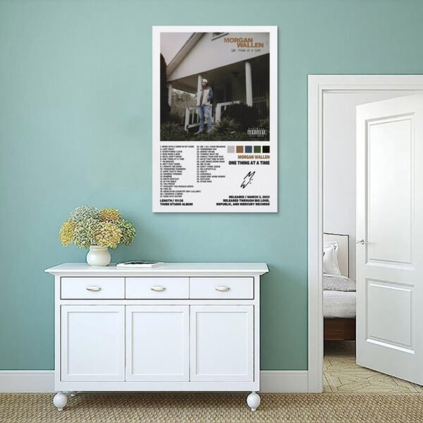 Morgan Wallen One Thing At A Time poster displayed on sage green bedroom wall above white sideboard in modern minimalist interior.