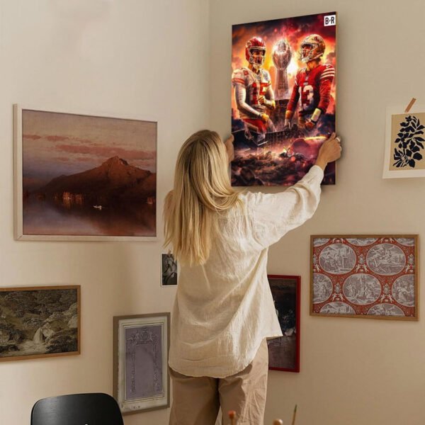 Woman hanging NFL Super Bowl championship canvas art on curated gallery wall in modern home interior design setting