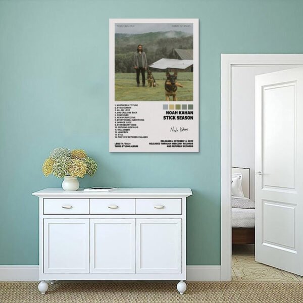 Noah Kahan Stick Season album poster displayed in mint green coastal bedroom with white furniture and natural textures