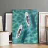 Original aerial surf canvas art displayed in professional artist studio showing two surfers on turquoise ocean waters with authentic creative workspace setting.