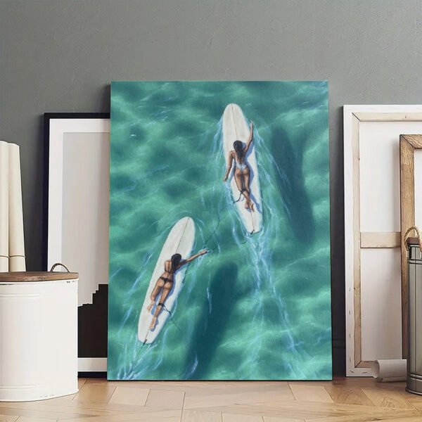 Original aerial surf canvas art displayed in professional artist studio showing two surfers on turquoise ocean waters with authentic creative workspace setting.