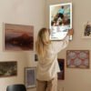 Person hanging Tyler The Creator Call Me If You Get Lost Estate Sale album poster on gallery wall with eclectic art collection in modern home interior