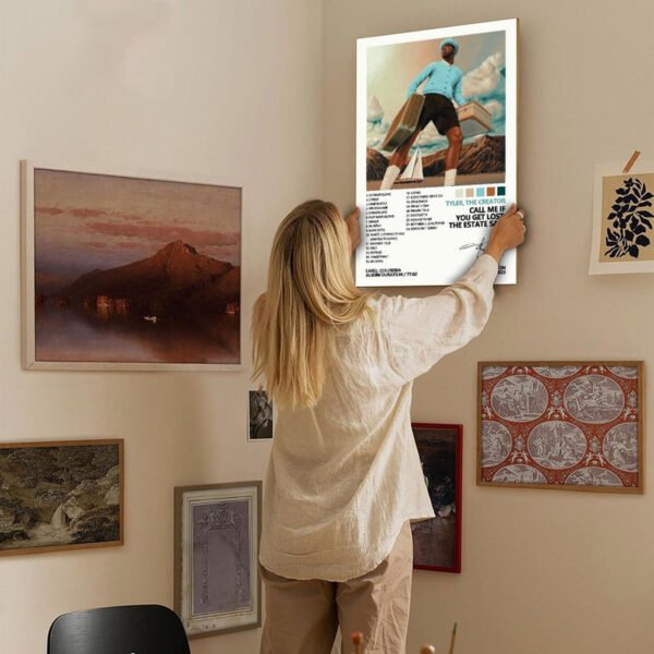Person hanging Tyler The Creator Call Me If You Get Lost Estate Sale album poster on gallery wall with eclectic art collection in modern home interior