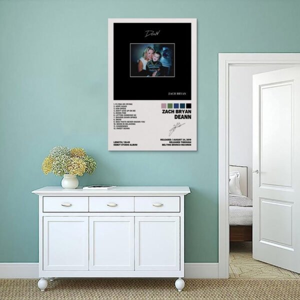 Zach Bryan DeAnn album poster displayed on sage green bedroom wall above white vintage sideboard with dried flowers