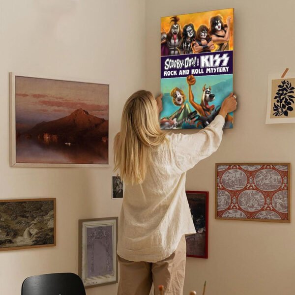 Woman hanging Scooby-Doo and KISS Rock and Roll Mystery canvas print on gallery wall in modern home interior with eclectic art collection.