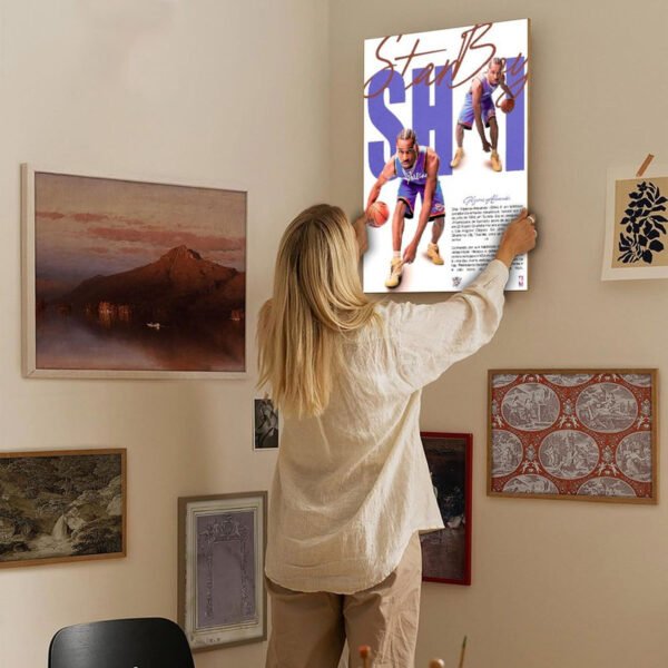 Woman hanging SGA Thunder basketball poster on curated gallery wall with mixed art collection in modern home interior