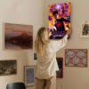 Person hanging Spider-Man Across the Spider-Verse poster on gallery wall with mixed art collection for home decor styling.