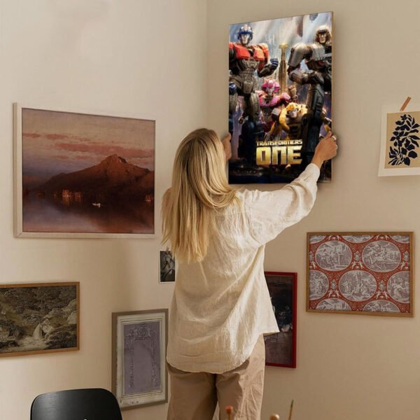 Woman hanging Transformers One canvas print on gallery wall with mixed art collection in modern home