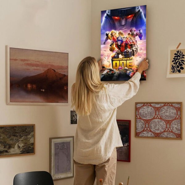 Woman hanging Transformers One movie poster canvas print on gallery wall in modern home interior showing scale and home decor integration.